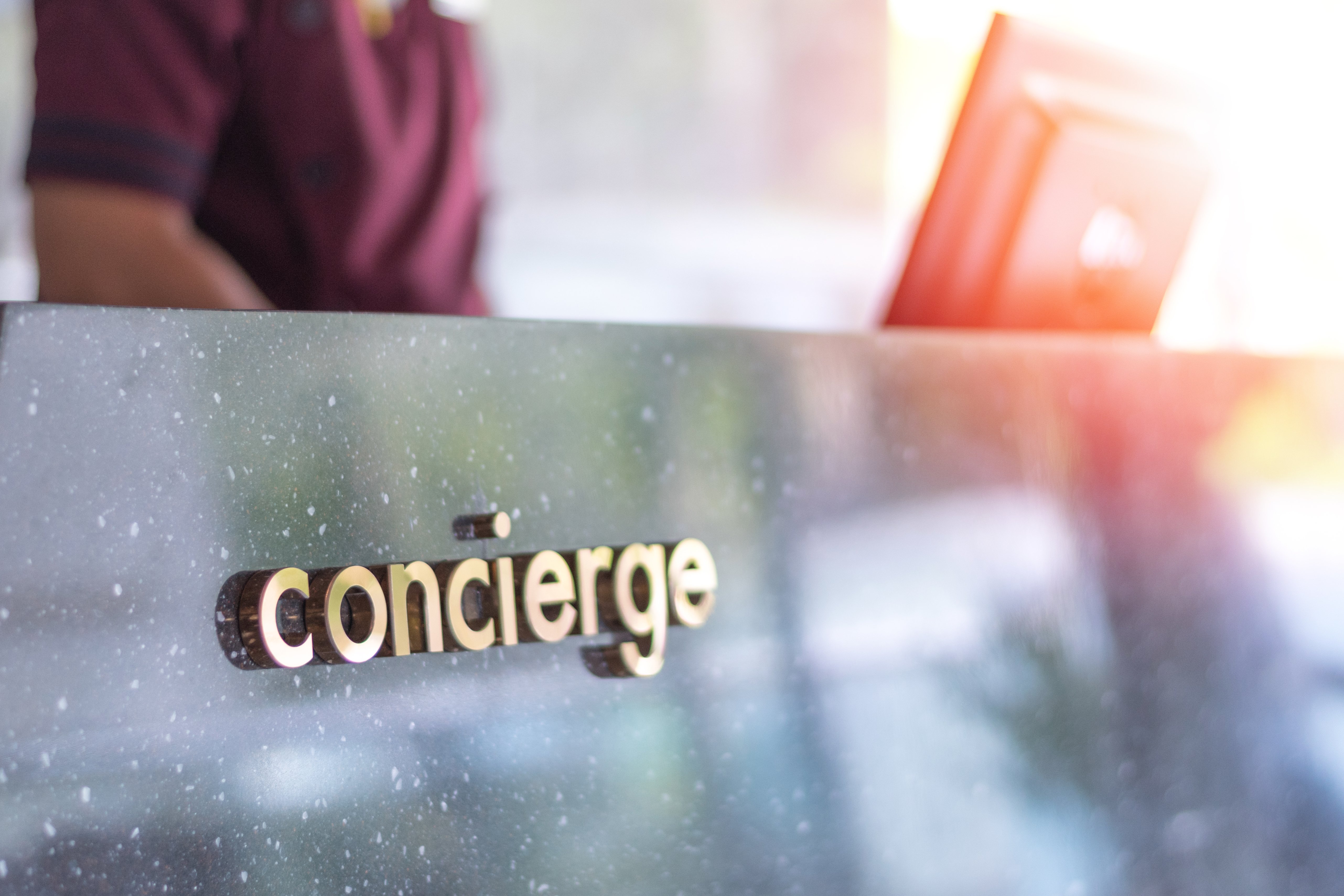 Concierge service desk counter with staff team working in front of hotel with tourist business customer.