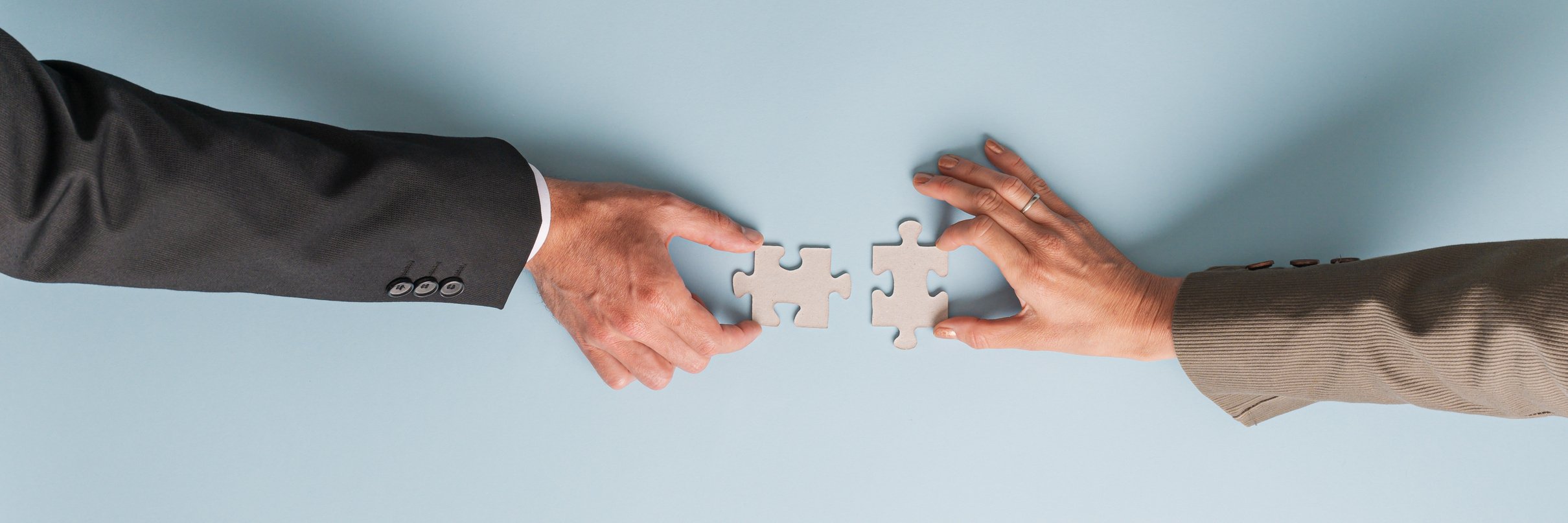 Man and Woman Matching Blank Puzzle Pieces Together